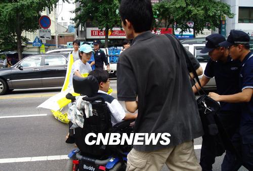 경찰이 기자회견을 방해하자 장애인들이 항의하며 전동 휠체어를 타고 종로경찰서 앞 차도로 뛰쳐나가고 있다. (사진=오재현 기자)