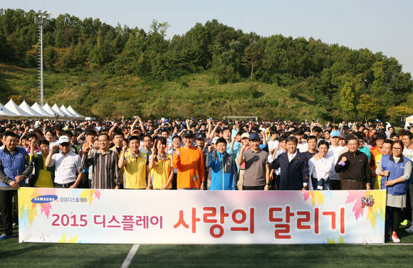 박동건 삼성디스플레이 사장(앞줄 가운데 주황색티셔츠)과 임직원들이 6일 충남 아산시 탕정면 삼성디스플레이 아산캠퍼스에서 열린 '2015 사랑의 달리기' 행사를 시작하기에 앞서 파이팅을 외치고 있다. (사진제공=삼성디스플레이)