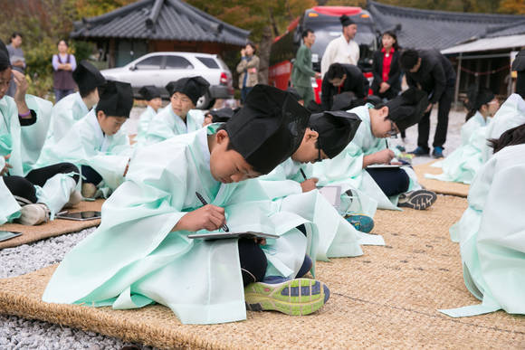 청학동 서당 어린이들이 옛 선비들이 입었던 도포와 유건을 착용하고 지·필·묵 대신 태블릿 PC와 앱을 활용해 과거시험을 치르고 있다. (사진제공=KT)