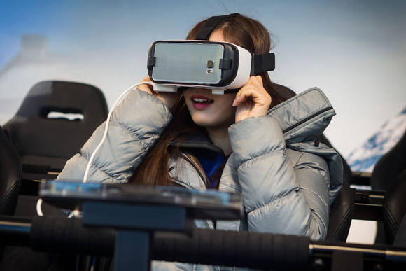 김연아 선수가 ‘기어 VR’과 4D 체험의자를 통해 스키점프 VR 콘텐츠를 체험하고 있다. (사진제공=삼성전자)