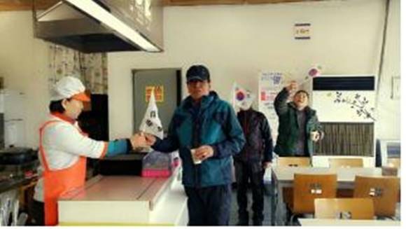 호남고속도로 3에 위치한 위즈코프(주) 순천휴게소에서 고객에게 차량용 태극기를 나눠주고 있다.(사진=순천휴게소)