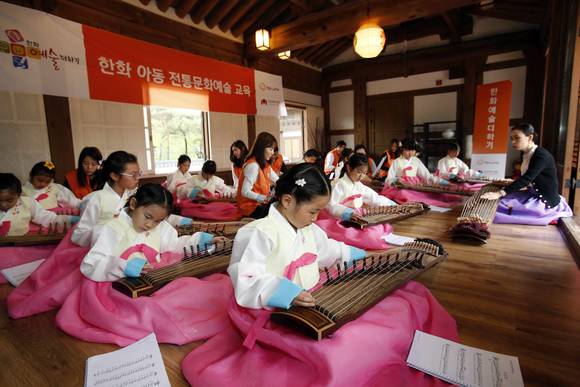 21일 서울 남산국악당 체험실에서 전통문화예술교육사업인 ‘한화예술더하기’ 사회공헌 활동에 참석한 한화그룹 임직원 봉사자들과 아동들이 가야금 교육에 참여하고 있다. (사진제공=한화그룹)
