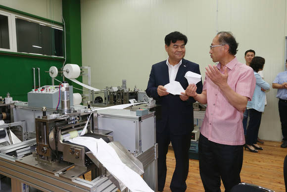 심규언 동해시장(사진 좌측)이 견운모마스크제작사업단 관계자로부터 제작과정 등에 대한 설명을 듣고 있는 모습. (사진=동해시청)