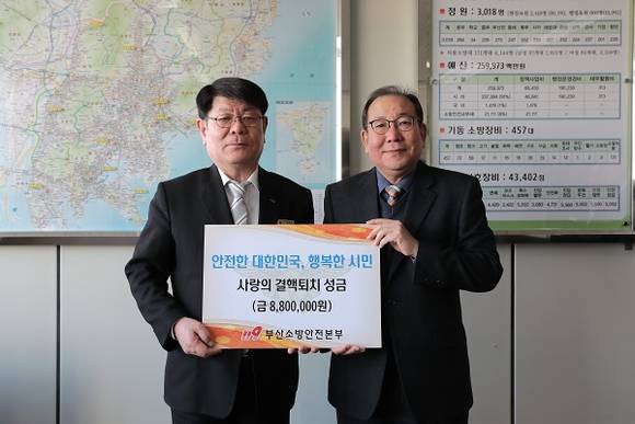부산 소방공무원 전원이 참여한 모금액 880만 원이 표시된 액자를 전달 모습. (사진제공=부산소방)