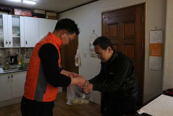 김용무 부산병무청장(왼쪽)이 망미1동 거주 어르신에게 직접 행복도시락 배달을 하고 있다. (사진제공=부산병무청)