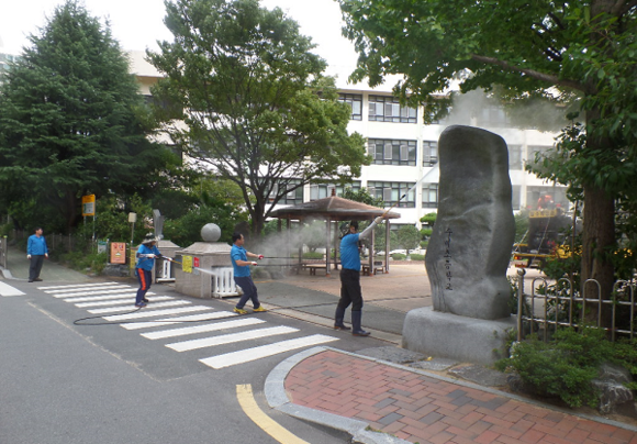 부산시설공단 직원들이 고압세척 장비로 학교 주변을 청소하고 있는 모습. (사진=부산시설공단)