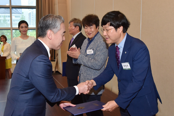 동아대 한성호 교수(오른쪽)가 박재민 부산시장 권한대행으로부터 표창장을 받고 악수하고 있다. (사진=동아대)