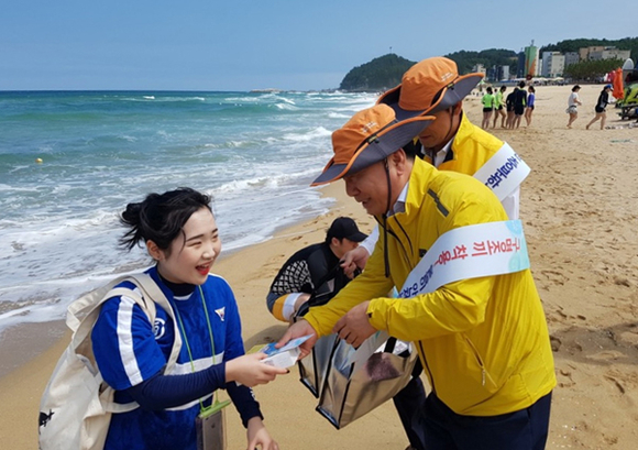 한국남부발전 고명석 기술안전본부장이 폭염과 물놀이 안전사고 예방에 대한 유인물을 삼척해수욕장을 찾은 피서객에게 나눠주고 있다. (사진제공=남부발전)