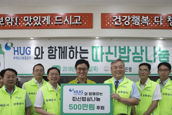 (가운데)강정칠 부산연탄은행 대표, (중앙 팻말 우측)이재강 HUG 상근감사위원, (중앙 팻말 좌측)오원택 HUG 감사실장과 감사실 직원들이 소외계층 급식 후원금 전달식 기념촬영을 하고 있다. (사진제공=HUG)