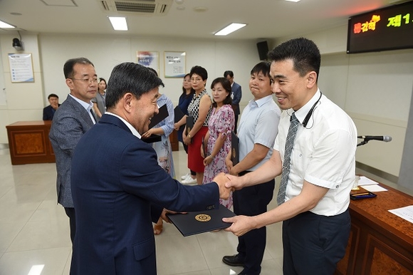 허성곤 김해시장(왼쪽)이 제1기 주민참여예산위원들에게 위촉장을 각각 전달하며 악수를 하고 있다. (사진=김해시)