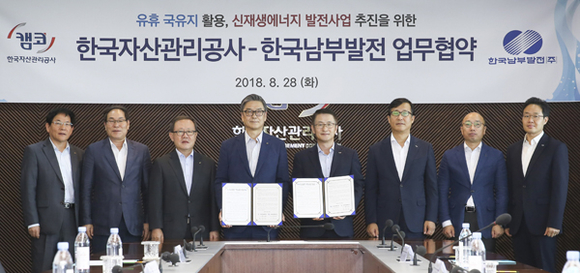 한국남부발전 신정식 사장(왼쪽 네 번째)과 한국자산관리공사 문창용 사장(다섯 번째)이 ‘유휴 국유지를 활용한 신재생에너지 발전사업 추진을 위한 업무협약’을 체결한 후 관계자들과 기념촬영을 하고 있다. (사진제공=남부발전)