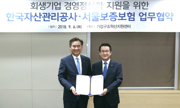 문창용 캠코 사장(사진 오른쪽)과 김상택 SGI서울보증 대표이사(사진 왼쪽)가 6일 캠코양재타워 기업구조혁신지원센터(서울센터)에서 '회생 기업 경영정상화 지원을 위한 업무협약'을 체결하고 기념촬영을 하고 있다. (사진제공=캠코)