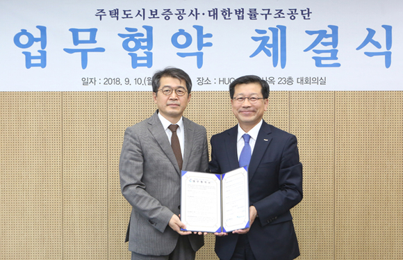 HUG 이재광 사장(오른쪽)과 대한법률구조공단 조상희 이사장(왼쪽)이 업무협약을 맺고 기념촬영을 하고 있다. (사진제공=HUG)