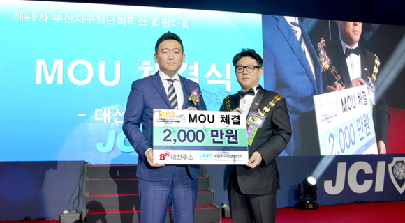 7일 대선주조 조우현 대표(왼쪽)가 부산지구청년회의소 장성민 회장(오른쪽)에게 후원금을 전달하고 기념촬영을 하고 있다. (사진제공=대선주조)