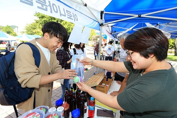 10일 부민캠퍼스 중앙광장에서 열린 '제2회 농산물 직거래 장터'에서 학생이 체험을 하고 있다. (사진제공=동아대)