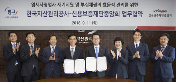 문창용 캠코 사장(오른쪽 네번째)과 김병근 신용보증재단중앙회 회장(왼쪽 네번째)이 11일 부산국제금융센터 본사 47층 대회의실에서 소기업·소상공인 등 영세자영업자 재기지원 및 부실채권 관리의 효율성 제고를 위한 업무협약을 체결하고 양기관 관계자들과 함께 기념촬영을 하고 있다. (사진제공=캠코)