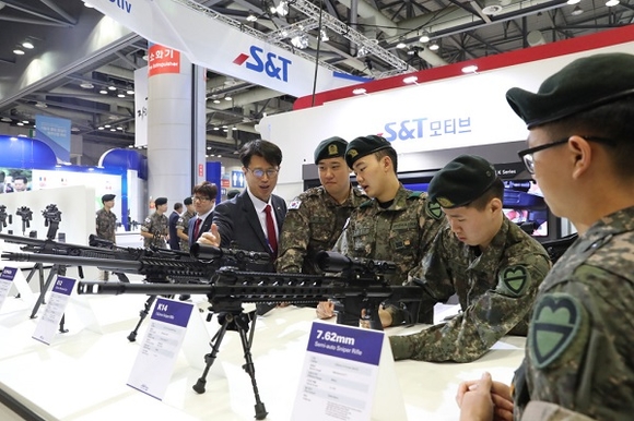 S&T모티브 특수영업팀 관계자가 S&T모티브 부스 내 7.62mm K-14 저격용 소총 전시품 앞에서 군인들에게 총의 성능과 특성 등을 설명하고 있다. (사진=S&T모티브)