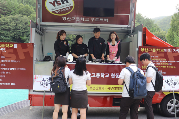 10일 영산고등학교 교사들이 푸드트럭에서 주먹밥을 만들어 학생들에게 전달하고 있다. (사진제공=영산대)