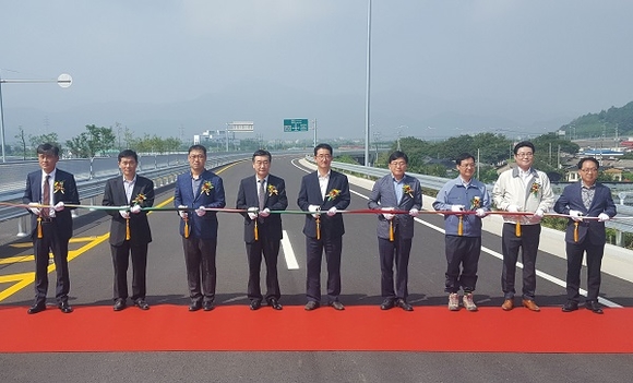 밀양역과 삼랑진 구간을 연결하는 58번 국도 개통식에서 내빈들이 테이프 커팅 전 기념촬영을 하고 있다. (사진=밀양시)