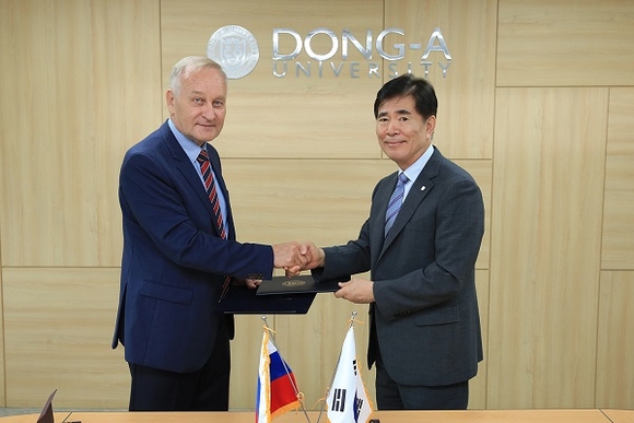 러시아 블라디보스톡국립경제서비스대학 제나디(왼쪽) 이사장과 한석정 동아대 총장이 협정서를 교환하고 악수를 하고 있다. (사진=동아대)
