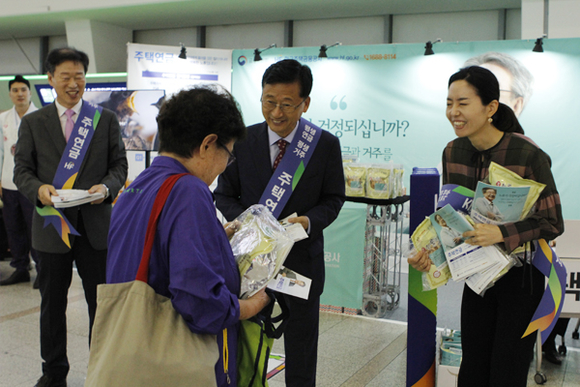 이정환 주택금융공사 사장(가운데)이 귀성객에게 명절 인사를 건네며 주택연금 홍보책자와 선물을 전달하고 있다. (사진제공=주택금융공사)
