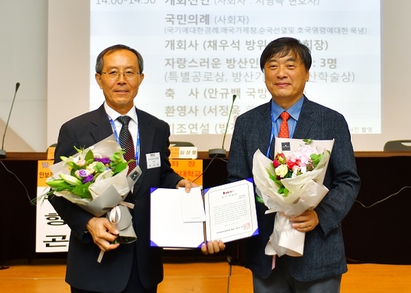 경남대 강재관 산학협력단장(오른쪽)이 자랑스러운 방산인상을 수상하고 한국방위산업학회 채우석 회장과 기념촬영을 하고 있다. (사진=경남대)