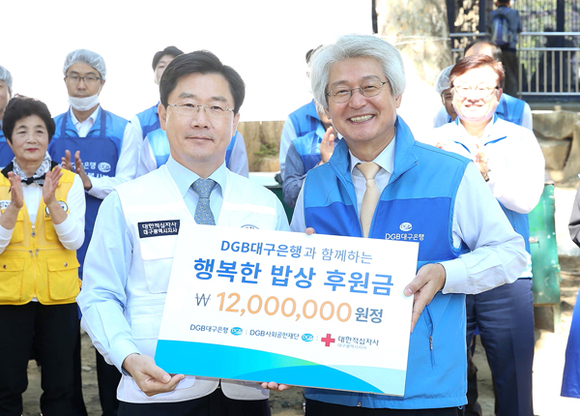 무료급식행사에서 DGB금융그룹 김태오 회장(오른쪽)이 대한적십자사 대구지사 송준기 회장(왼쪽)에게 연간 급식 후원금 전달하고 기념촬영을 하고 있다. (사진제공=DGB대구은행)