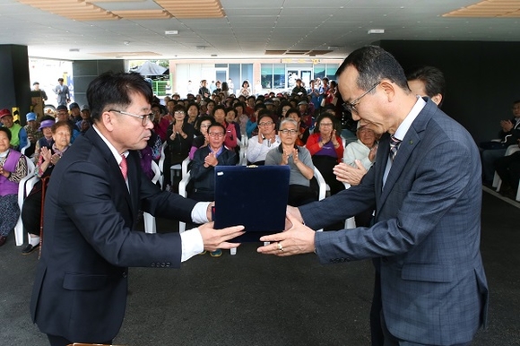 2일 '주민복지메디컬하우스' 준공식에 참여한 월내마을 조원호 이장(왼쪽)이 노기경 고리원자력본부장에게 감사패를 증정하고 있다. (사진=고리원자력본부)