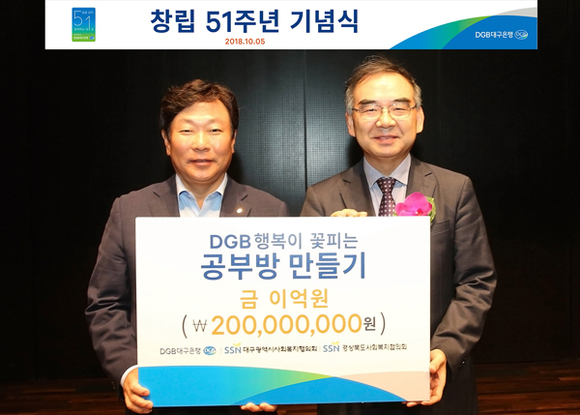 박명흠 DGB대구은행장 직무대행이 대구시사회복지협의회 이재모 회장에게 ‘DGB행복이 꽃피는 공부방 만들기’ 기부금 전달을 하고 있다. (사진제공=DGB대구은행)