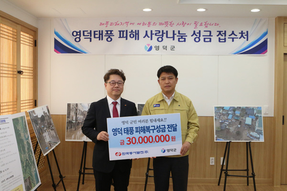 박일준 한국동서발전 사장(왼쪽)이 이희진 영덕군수(오른쪽)에게 태풍 피해 복구 성금을 전달하고 있다. (사진제공=동서발전)