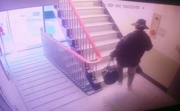 모자와 선글라스를 착용한 용의자가 범행도구가 들어 있는 것으로 추정되는 큰 가방을 들고 들어가는 모습이 아파트 CCTV에 잡혔다. (사진제공=부산경찰청)