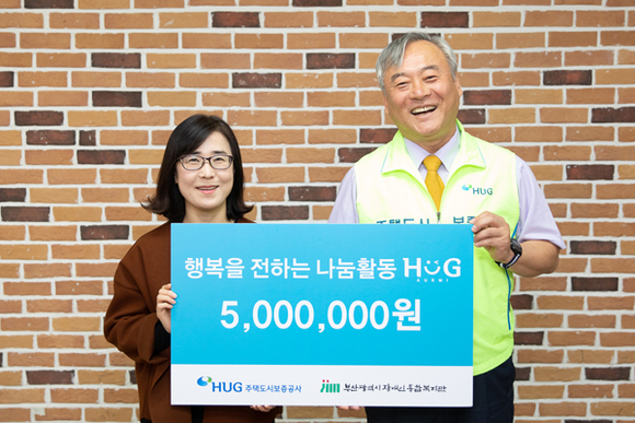이재강 HUG 상근감사위원(오른쪽)과 김정자 부산시 장애인종합복지관 사무국장(왼쪽)이 HUG 감사인 나눔활동 후원금 전달식 기념촬영을 하고 있다. (사진제공=HUG)